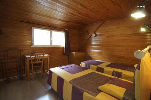 a bedroom with two beds and a table and a window at Claveyrolas in Nedde