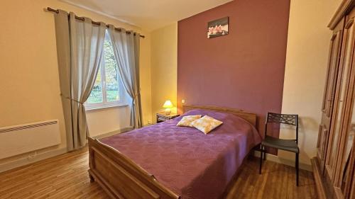 a bedroom with a purple bed and a window at Péret in Saint-Denis-des-Murs