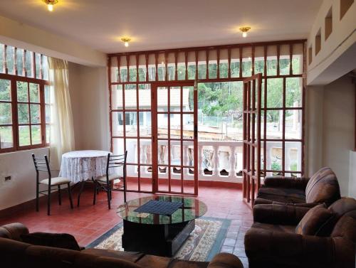 a living room with a couch and a table at Sumaq Illary Bonito Amanecer in Urubamba