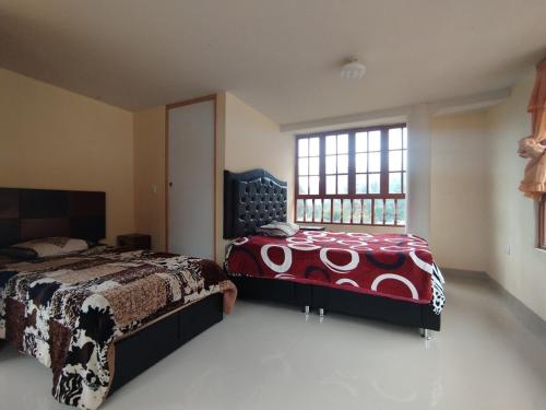 a bedroom with two beds and a window at Sumaq Illary Bonito Amanecer in Urubamba