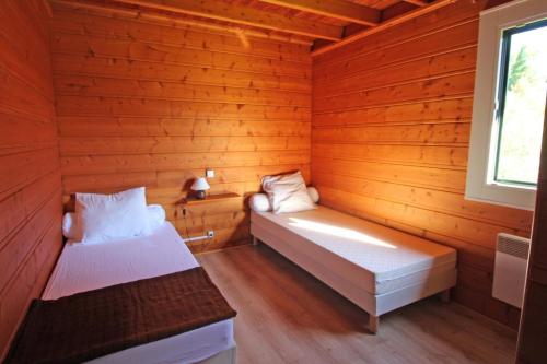 a room with two beds in a wooden cabin at Gîte 87G5513 in Sussac