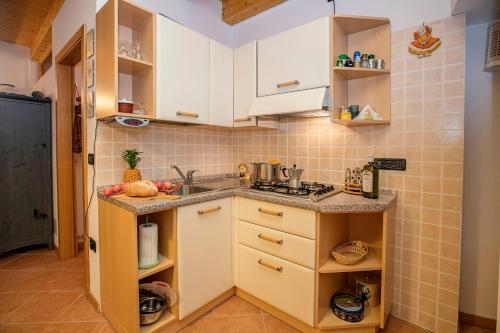 a small kitchen with white cabinets and a sink at Appartamento Centro Storico Riva - Happy Rentals in Riva del Garda
