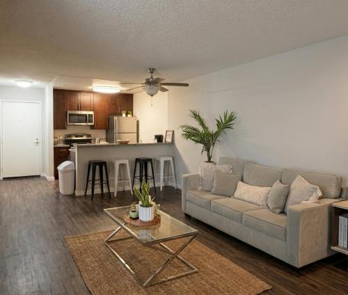 a living room with a couch and a kitchen at Modern 2BR Hollywood Apt with Rooftop Pool, Free Parking & Close to Walk of Fame and Universal Studios in Los Angeles