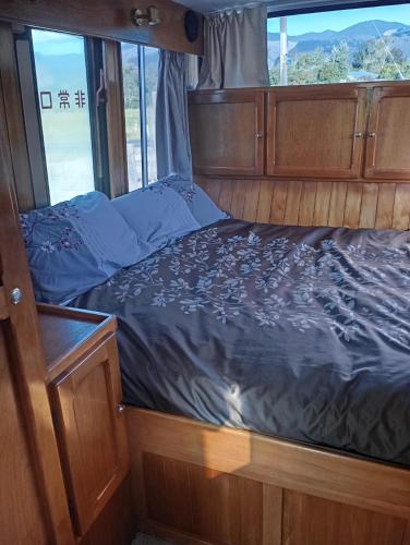 a bed in the back of a boat at Cruzo The House Bus in Takaka