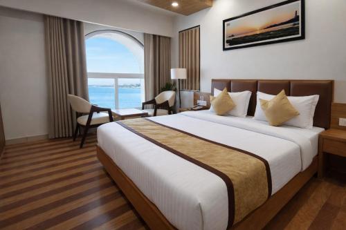 a hotel room with a large bed and a window at Hotel The Tulip in Diu