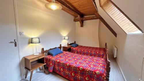 a bedroom with a bed and a table with a lamp at Cirèges in Le Chalard