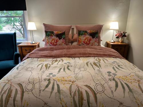 a bedroom with a large bed with flowers on it at Bush Retreat Farm Stay 1BR Guest Suite in Alberton West