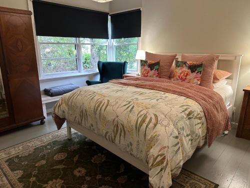 a bedroom with a bed and a chair and a window at Bush Retreat Farm Stay 1BR Guest Suite in Alberton West