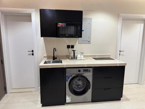 a kitchen with a washing machine and a sink at رولارا بلازا in Medina