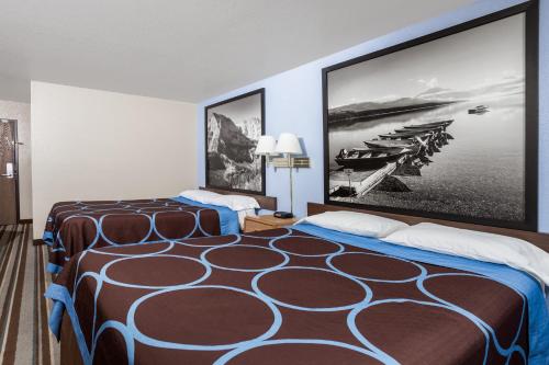a hotel room with two beds and a picture of boats at Grizzly Inn in Great Falls