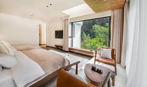a bedroom with a bed and a large window at Taofanting Riverside Hotel in Yichang
