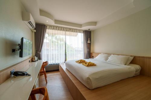 a hotel room with a bed with towels on it at Diamond Park Inn Chiangrai & Resort in Chiang Rai