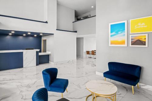 a lobby with blue chairs and a table at Days Inn by Wyndham Dallas Plano in Plano