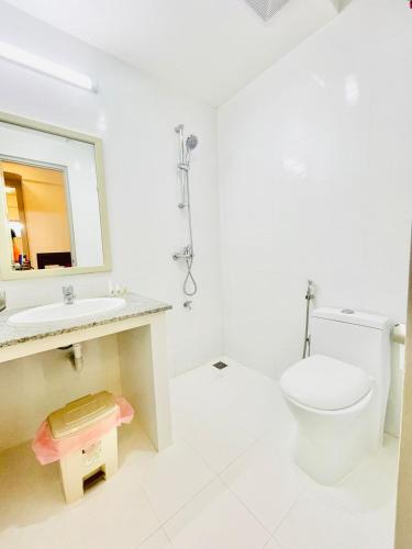 a bathroom with a toilet and a sink and a mirror at HS Miracle Grand in Hulhumale