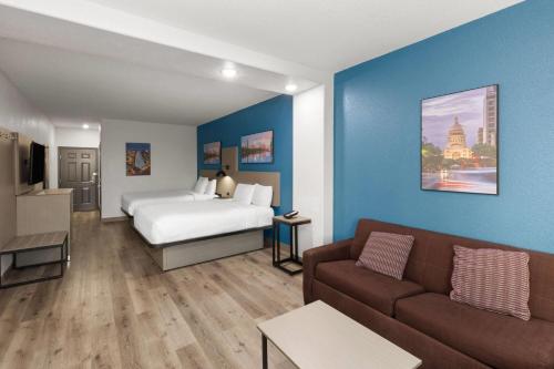 a hotel room with a bed and a couch at La Quinta by Wyndham Kyle - Austin South in Kyle