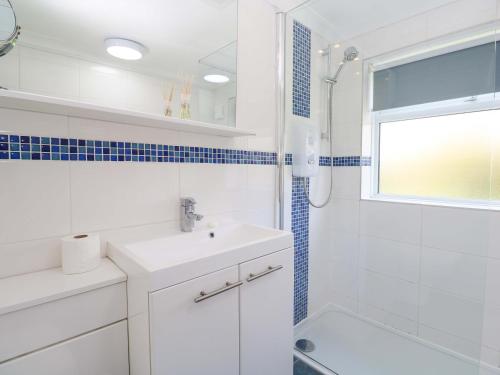 a white bathroom with a sink and a shower at Atlantic Waves in Carbis Bay