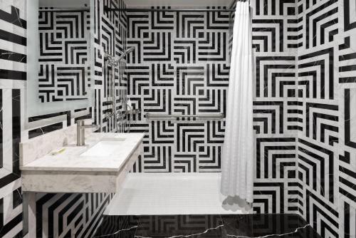 a bathroom with a black and white patterned wall at Super 8 by Wyndham Bronx Near Stadium in Bronx