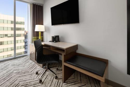 a hotel room with a desk and a television at Super 8 by Wyndham Bronx Near Stadium in Bronx