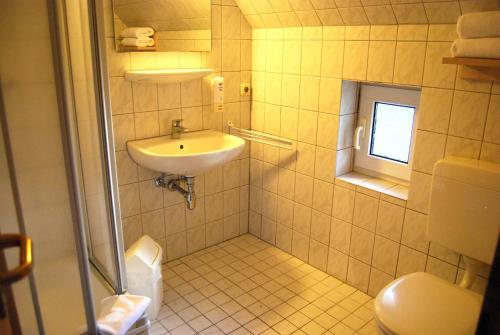 ein Bad mit einem Waschbecken und einem WC in der Unterkunft Doppelhaushälfte in Vitte auf Hiddensee in Vitte