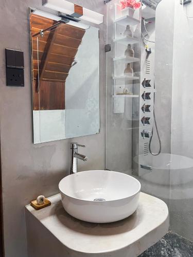 a bathroom with a white sink and a shower at 8 Acres Tea Escape in Deniyaya