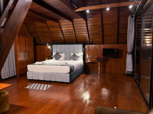 a bedroom with a bed in a room with wooden floors at 8 Acres Tea Escape in Deniyaya