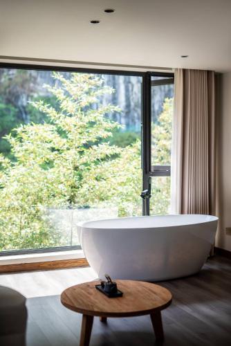 a bathroom with a tub and a large window at Taofanting Riverside Hotel in Yichang