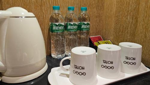 Ein Mixer und Becher auf einem Tablett mit Wasserflaschen in der Unterkunft GOGO Hotel City Hall in Taichung