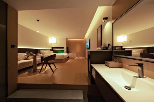 a bathroom with a sink and a living room at a1 Art Hotel in Quanzhou