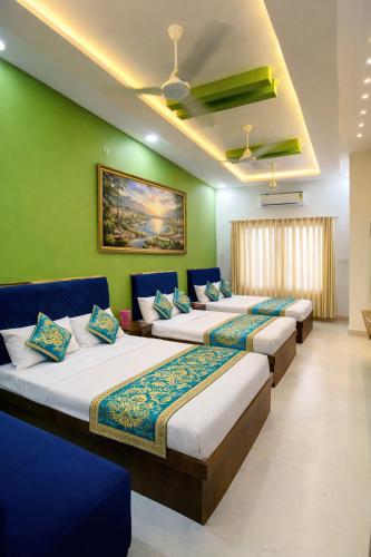 a row of beds in a room with green walls at Hotel Tirupati Heights Ujjain # Near Railway Station # Top Rated Property in Ujjain