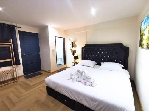 a bedroom with a bed with white sheets and a blue door at The One Hotel in Pattaya
