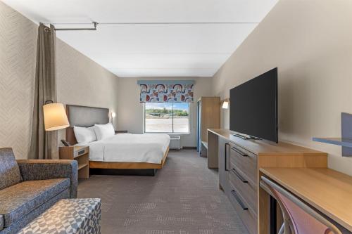 a hotel room with a bed and a television at Home2 Suites By Hilton Calera in Calera