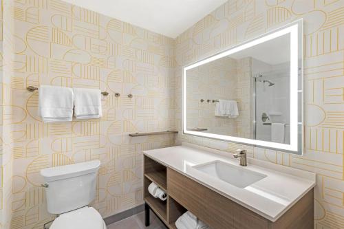 a bathroom with a toilet and a sink and a mirror at Home2 Suites By Hilton Calera in Calera