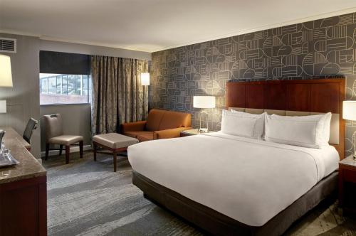 a hotel room with a large bed and a chair at DoubleTree by Hilton Akron Fairlawn in Fairlawn