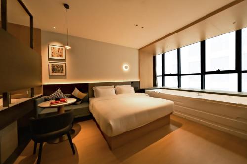 a bedroom with a bed and a desk and a table at a1 Art Hotel in Quanzhou