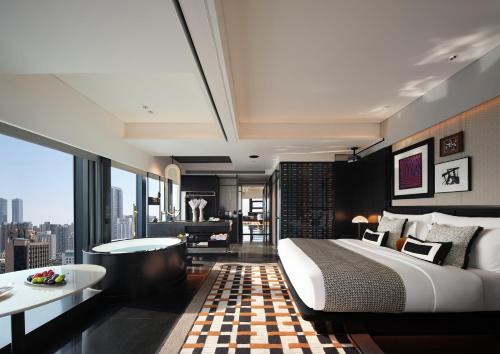 a bedroom with a large bed and a tub and a table at SEYA Design Hotel - Chengdu Taikoo Li - Managed by SEYA GROUP in Chengdu