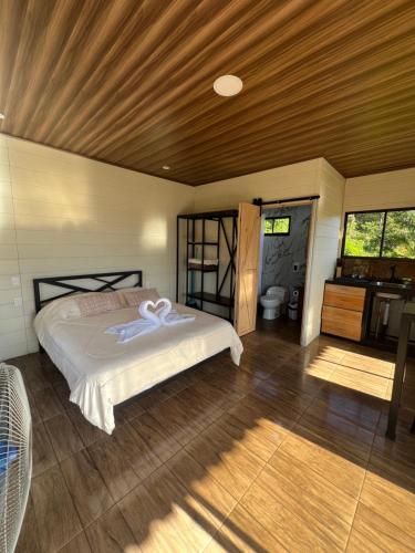 a bedroom with a bed and a wooden ceiling at La cabaña del Colibrí in Bijagua