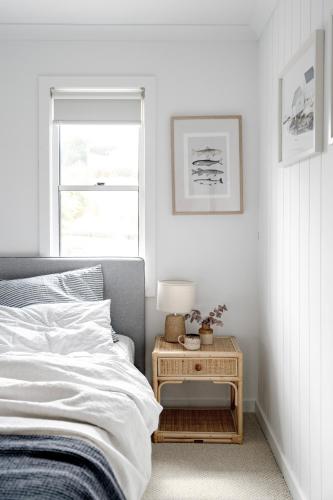 a bedroom with a bed and a table with a lamp at Shack In The Dunes in Weymouth