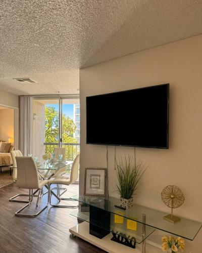 a living room with a flat screen tv on a wall at Modern 2BR Hollywood Apt with Rooftop Pool, Free Parking & Close to Walk of Fame and Universal Studios in Los Angeles