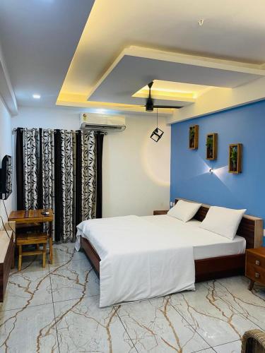 a bedroom with a large bed and a blue wall at JK Residency in Kunnamangalam
