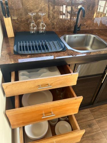a kitchen counter with wooden drawers and a sink at La cabaña del Colibrí in Bijagua