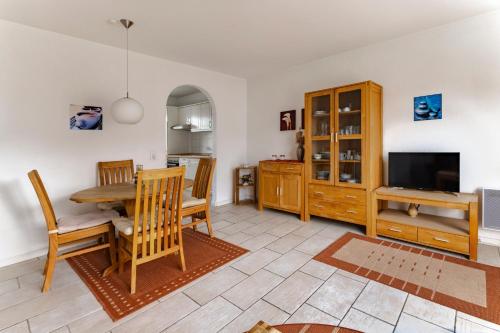 a kitchen and dining room with a table and a television at Haus am Kurhaus 9 in Nordstrand