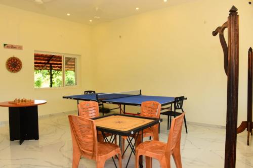 a dining room with a ping pong table and chairs at Skandavanam in Tiruvallūr