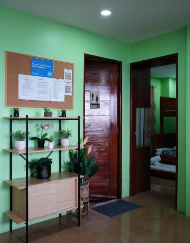a room with green walls and a door with potted plants at Mountain and Sunsetview Baguio Residences in Baguio