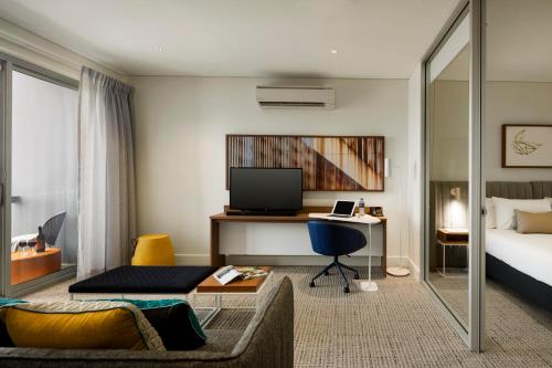a hotel room with a bed and a desk at Quest Port Adelaide in Adelaide