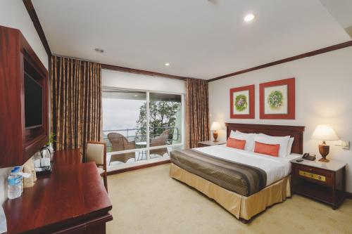a hotel room with a bed and a balcony at Hunas Falls in Kandy