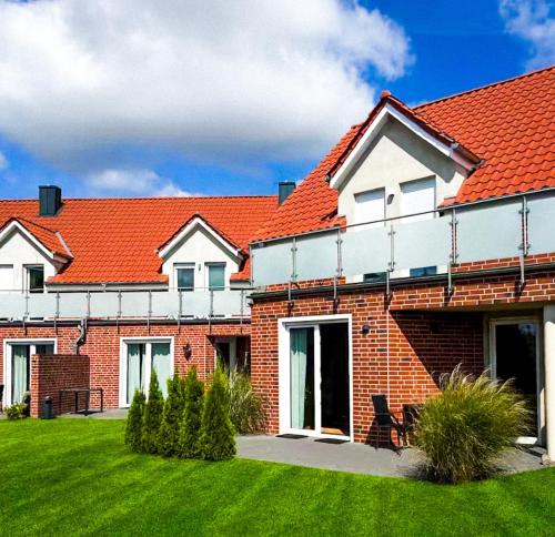 a brick house with an orange roof at Privates Team-Haus nahe VW Wolfsburg I 4-5 Schlafzimmer, Einzelbetten, perfekt für Monteure, Teams und Reisegruppen I Parkplatz I Rechnung mit MwSt in Calberlah