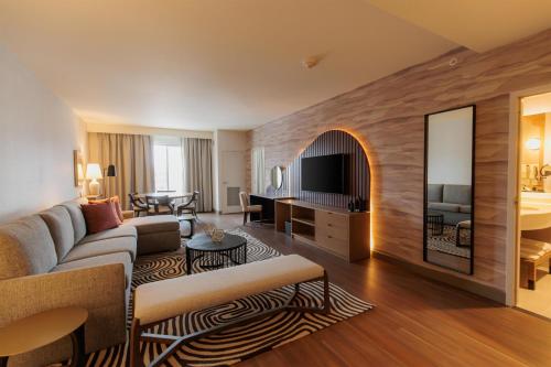 a living room with a couch and a television in a room at Hilton Garden Inn Sioux Falls Downtown in Sioux Falls