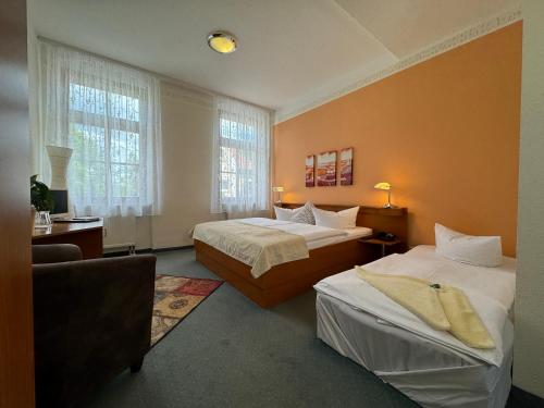 a hotel room with two beds and a couch at Logis Hotel Stadt Neustadt in Neustadt