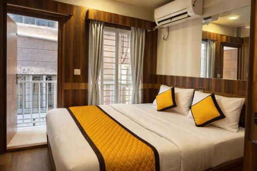 a bedroom with a bed with yellow and white pillows at Nova Regency in Bangalore