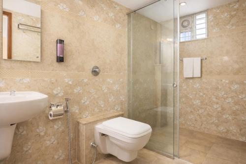 a bathroom with a toilet and a sink and a shower at Nova Regency in Bangalore